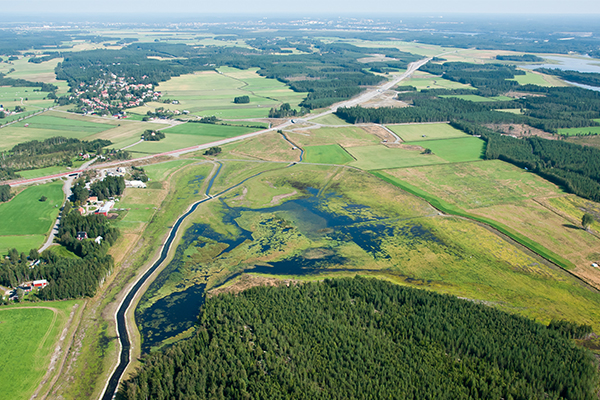 Flygbild över naturreservatet Storavan i Stöcke by med Södra Degernässlätten-Sundet och Västerfjärden i bakgrunden. På bilden ser man både restaurerade strandängar, nyanlagda våtmarker, åkermarker och hur Botniabanan går rakt igenom området samt Umeå stad i bakgrunden.